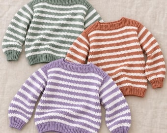 Puede incluir: Tres jerséis de punto de manga larga con rayas horizontales en verde salvia, naranja terracota y lavanda, combinados con blanco. Los jerséis tienen cuello redondo, puños acanalados y un dobladillo acanalado con una textura de punto.