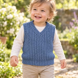 May include: A blue V-neck sweater vest featuring a vertical ribbed knit pattern, worn over a long-sleeved cream-colored shirt paired with light tan trousers. The vest has a thick ribbed hem and armhole trim, providing a textured appearance.
