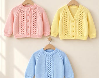 Puede incluir: Tres suéteres de punto de manga larga colgados en perchas de madera. Arriba a la izquierda, un cárdigan rosa claro con botones, arriba a la derecha, un cárdigan amarillo claro con botones y abajo en el centro, un suéter azul claro.
