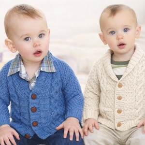 Puede incluir: Dos niños pequeños con cárdigans de punto. Uno lleva un cárdigan azul sobre una camisa a cuadros, el otro un cárdigan crema sobre una camisa a rayas. Ambos cárdigans tienen botones de madera.
