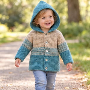 May include: A hooded knit cardigan featuring a colour-blocked design with a teal hood and lower section, a tan middle section, and long sleeves. The garment is fastened with four light-coloured buttons down the centre front and has a textured knit.