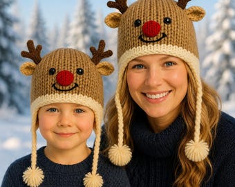 Puede incluir: Dos gorros de punto color canela a juego con nariz de pompón rojo, ojos de botón negro, una sonrisa bordada y astas marrones. Cada gorro tiene un borde acanalado color crema y dos largas orejeras trenzadas con pompones de hilo color crema.