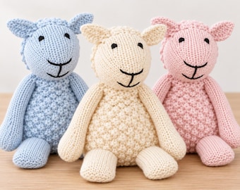 Puede incluir: Tres peluches de oveja en azul claro, crema y rosa claro. Cada oveja presenta un cuerpo con textura de punto de palomitas, cabeza y extremidades de punto liso, y ojos y boca bordados en color negro.