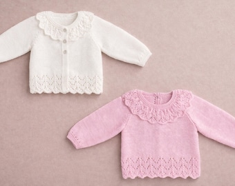 Puede incluir: Dos suéteres para bebés, uno blanco y otro rosa, con cuellos y dobladillos festoneados. El suéter blanco es una rebeca con botones. El suéter rosa es un jersey. Ambos tienen mangas largas y están hechos de un material de punto suave.