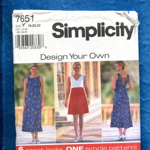 May include: Simplicity sewing pattern featuring three women modeling dresses. The pattern includes six different dress designs. The text on the pattern reads "Design Your Own" and "6 great looks. ONE simple pattern!"