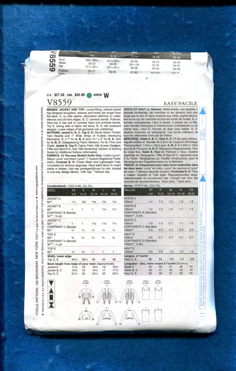 Op de afbeelding: Een gevouwen patroon-envelop voor Vogue V8559, met instructies voor een jas en top. De envelop toont maattabellen, stofvereisten en illustraties van de kledingontwerpen. Het kleurenschema is voornamelijk wit en blauw.