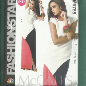 May include: A McCall's Fashion Star sewing pattern, M6755, featuring a color-blocked dress design. The dress has a white top, a black and coral skirt, and a high slit. The pattern includes size D5 (12-14-16-18-20) and the word "EASY".