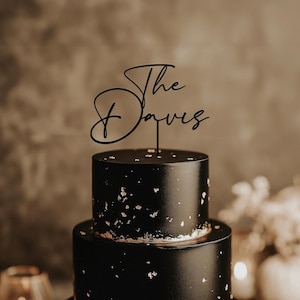 May include: A white ceramic mug with a black handle and the text "But First, Coffee" in a handwritten style. The mug is on a white surface. The mug is approximately 4 inches tall.