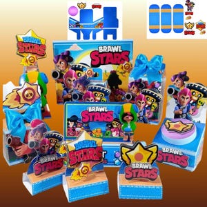 May include: A selection of Brawl Stars party decorations. The image shows boxes, cutouts, and toppers with the game's logo and characters. The colour scheme is mainly blue, yellow, and red, with a cartoon style.
