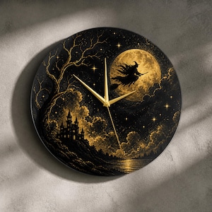 May include: A round wall clock featuring a black and gold illustration of a witch flying on a broomstick in front of a full moon. The scene includes a dark castle on a hill, a bare tree, and a starry night sky. It has three thin gold clock hands.