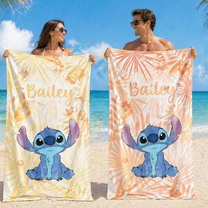May include: Two beach towels with a cartoon character design. One is yellow with floral patterns, the other is orange. Both towels feature the name "Bailey". The towels are ideal for the beach or pool.