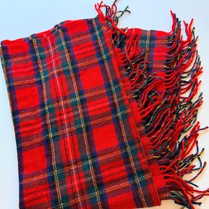 Puede incluir: Bufanda a cuadros roja con borde de flecos. La bufanda presenta un patrón de tartán clásico en rojo, verde, azul y amarillo. Los flecos son una mezcla de hilos rojos, negros y amarillos. Un accesorio cálido para el invierno.