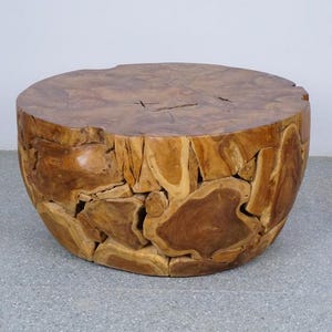 Op de afbeelding: Een ronde houten salontafel met een natuurlijke afwerking. De tafel is gemaakt van verschillende stukken hout, waardoor een uniek, moza&iuml;ekachtig patroon ontstaat. De tafel heeft een diameter van ongeveer 61 cm en is 46 cm hoog.