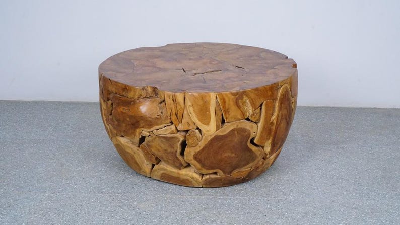 Op de afbeelding: Een ronde houten salontafel met een natuurlijke afwerking. De tafel is gemaakt van verschillende stukken hout, waardoor een uniek, moza&iuml;ekachtig patroon ontstaat. De tafel heeft een diameter van ongeveer 61 cm en is 46 cm hoog.