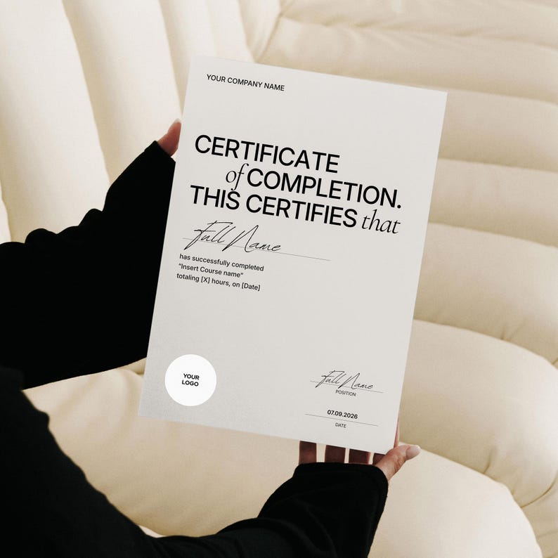 May include: A white certificate with black text, held by a person. The certificate reads "CERTIFICATE of COMPLETION. THIS CERTIFIES that" followed by a name and other details. The certificate also includes a logo and a date.