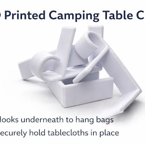 May include: White 3D-printed camping table clips. The image shows several clips with a hook design for hanging bags and a secure hold for tablecloths. Text on the image reads: 3D Printed Camping Table Clips.