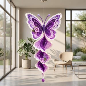 Peut inclure: Un mobile papillon en crochet suspendu aux tons violet, lavande et blanc. Le papillon possède une queue en spirale ornée de deux petites fleurs crochetées et d'une perle violette à l'extrémité, le tout suspendu par un fil métallique fin.