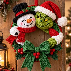 May include: A crochet wreath featuring a white snowman with a black top hat and red scarf alongside a green character wearing a red Santa hat with white trim. The wreath is decorated with a large green bow and red berries, all crafted in yarn.