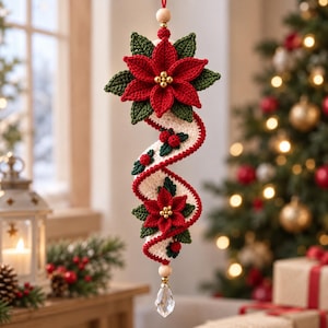Pode incluir: Um ornamento de crochê suspenso com duas flores de poinsétia vermelhas com folhas verdes e pequenas contas douradas no centro. Uma fita espiralada na cor creme com bordas vermelhas é decorada com pequenas bagas vermelhas e folhas, terminando em um cristal.