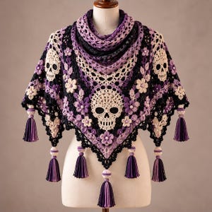 May include: A triangular crochet shawl featuring a repeating skull and floral motif in cream, purple, and black yarn. The shawl is adorned with small beads at the center of each flower and finished with multiple long, two-toned purple and black tassels.