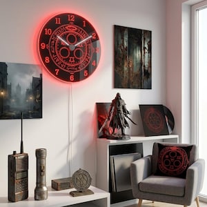Könnte beinhalten: Eine runde Wanduhr mit schwarzem Zifferblatt, rot leuchtenden Zahlen und einem rot beleuchteten Rand. Die Uhr zeigt ein zentrales kreisförmiges Emblem mit komplexen Symbolen und einem Auge, ergänzt durch weiße Zeiger.