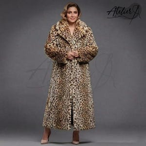 May include: A full-length leopard print coat with a wide collar and long sleeves. The coat features a classic button-down design and is made of a soft, faux fur material. The coat is a neutral color with brown and black spots.