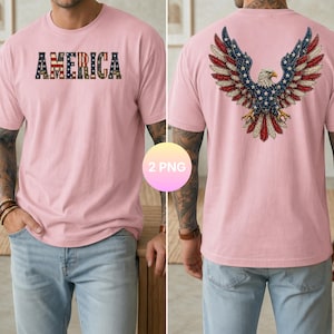 May include: A light pink t-shirt with the word "AMERICA" across the chest in a patriotic flag design. The back of the shirt features a detailed eagle with outstretched wings, also in a flag-inspired design. The shirt is a short-sleeved crew neck.