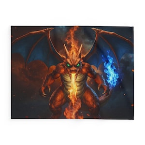 Puede incluir: Una manta cuadrada con una ilustración de un dragón que escupe fuego. El dragón es naranja con alas azules y ojos verdes. El fondo es oscuro con llamas naranjas y azules.
