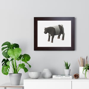 Op de afbeelding: Een ingelijste print met een geometrische illustratie van een koe. De koe is afgebeeld in zwart, grijs en wit, met een bruine lijst. Het kunstwerk heeft een moderne, minimalistische uitstraling, geschikt voor interieurdecoratie.
