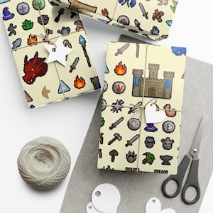 May include: Three wrapped gifts with pixelated fantasy-themed patterns, tied with twine and star-shaped tags. The wrapping paper features images of dragons, castles, swords, and other game-related icons. A ball of twine, scissors, and blank tags are also visible.