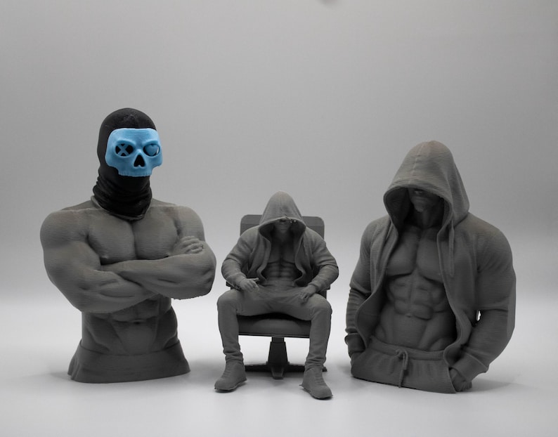 May include: Three gray 3D printed figures. On the left, a muscular torso bust wearing a black balaclava and a light blue skull mask. In the center, a seated figure in a hooded sweatshirt. On the right, a muscular torso bust wearing a hooded sweatshirt.