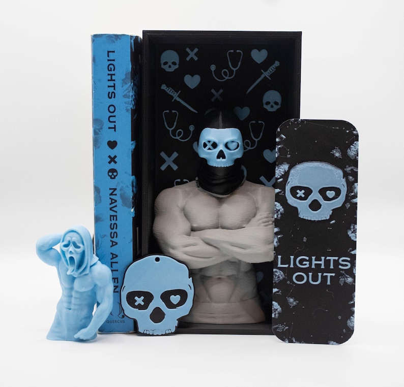 May include: A collection of horror-themed items, including a book titled "LIGHTS OUT" and a bookmark with the same title. The items feature a skull design and a figure with a skull mask. The color palette is primarily blue and black.