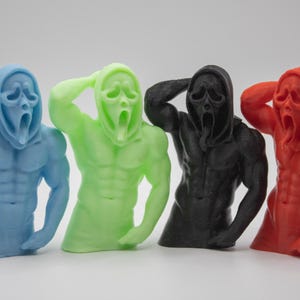 Puede incluir: Cuatro figuras coloridas en azul, verde, negro y rojo, cada una representando una figura musculosa con una m&aacute;scara de Scream. Las figuras posan con un brazo levantado hacia la cabeza y tienen una expresi&oacute;n de boca abierta.