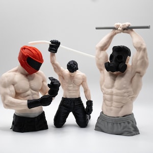 May include: Three muscular male figurines. The left figure wears a red helmet and black gloves. The center figure kneels, wearing black pants and gloves, holding a white hockey stick. The right figure wears a black gas mask and grey shorts.