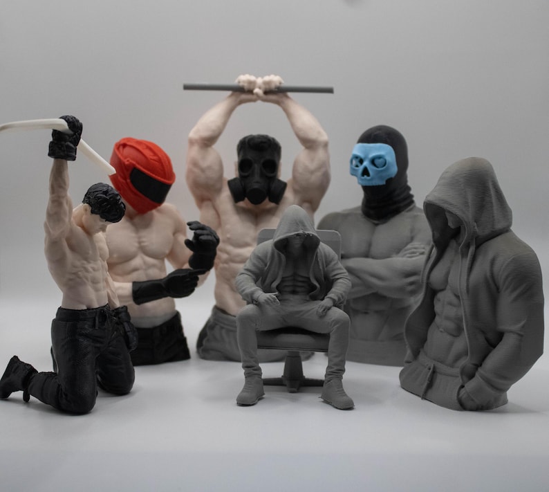 May include: A collection of six muscular male figurines in various poses. One kneels with a white whip, one wears a red helmet, one lifts a bar with a gas mask, one sits in a chair wearing a hoodie, one wears a blue skull mask, and one wears a gray hoodie.