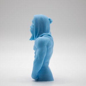 Puede incluir: Una figura azul claro de una figura musculosa con capucha. La escultura es detallada, mostrando la forma del cuerpo y la textura de la tela. La figura est&aacute; de pie en una pose relajada.