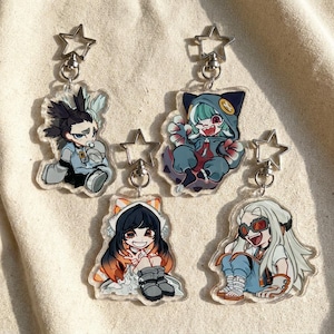 May include: Five acrylic anime-style character keychains. Each keychain features a unique character design with vibrant colors and detailed artwork. The keychains are attached to silver-colored star-shaped clasps.