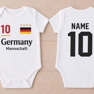 May include: White baby bodysuit with the number 10 and the word "Germany" printed on the front. The German flag and four gold stars are also displayed. The back of the bodysuit has the number 10 and the word "NAME".