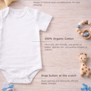 May include: A white baby onesie with an envelope neckline and snap buttons at the crotch. The onesie is made of 100% organic cotton. The image also includes a star-shaped plush toy, a wooden teether, a giraffe toy, and a pacifier.