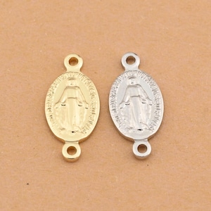 May include: Two oval-shaped religious pendants. One is gold-colored, the other is silver-colored. Each pendant features a detailed depiction of a religious figure within an oval frame, with a loop at the top and bottom for attachment.