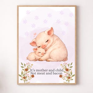Könnte beinhalten: Gerahmter Kunstdruck mit einer Aquarellillustration einer Muttersau und ihrem Baby, die sich umarmen. Der Hintergrund ist ein weiches Lila mit floralen Akzenten. Der Text unten lautet: "It's mother and child, Not meat and bacon."