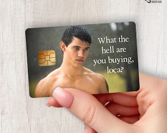 Puede incluir: Una tarjeta de crédito rectangular con la imagen de un hombre sin camisa y cabello oscuro bajo la lluvia. El texto "What the hell are you buying, loca?" aparece en blanco a la derecha. Un chip electrónico dorado es visible a la izquierda.