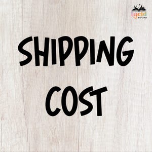 May include: A square graphic with a light wood grain background featuring the black text SHIPPING COST in a bold sans-serif font. In the top right corner, there is a small logo with the text Lucid Bound and a stylized open book icon.