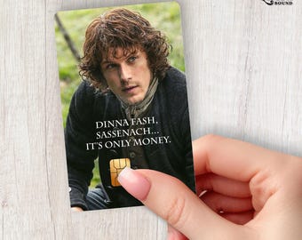 Puede incluir: Una tarjeta rectangular con el retrato de una persona de cabello castaño ondulado que viste una chaqueta oscura y una bufanda. El texto dice DINNA FASH, SASSENACH... IT'S ONLY MONEY. Un chip rectangular de color dorado es visible en el centro.
