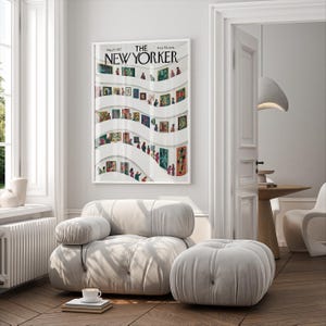May include: A framed "The New Yorker" magazine cover from May 23, 1977, featuring an art gallery scene with colorful paintings and figures. The artwork is displayed in a bright, modern living room with a white sofa and ottoman.