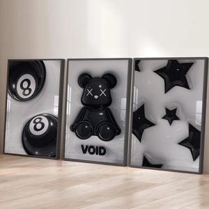 May include: Three framed art pieces. The left frame features two black 8-balls. The center frame displays a black bear figure with the word "VOID" below. The right frame shows black star shapes. All pieces have a glossy finish.