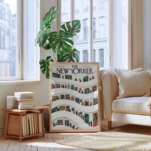 May include: A framed New Yorker magazine cover featuring an art gallery scene with people viewing paintings. The cover has a wooden frame and is displayed in a well-lit room with a large plant and a beige sofa.