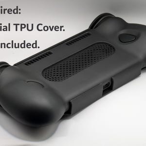 May include: A black TPU protective cover for a handheld gaming device, featuring a textured central mesh panel, ergonomic side grips, and precise cutouts for ports and buttons. The text "Required: Official TPU Cover. Not Included." is visible.