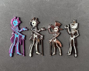 May include: Four enamel pins featuring skeleton figures in various outfits. One is purple with a fox-like head, another is a pirate, a third wears a top hat, and the last has a TV head. Each pin has a cane and a metallic finish.