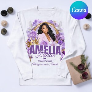 May include: White sweatshirt featuring a portrait of a woman surrounded by purple flowers, doves, and a gold crown. The name "Amelia Lanae" is displayed in purple script, with the text "Forever Loved, Forever Missed, Always in our Hearts."